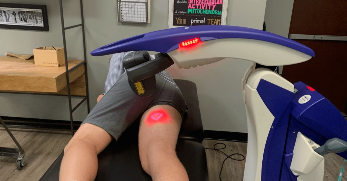 man laying in laser therapy machine with laser on inner thigh