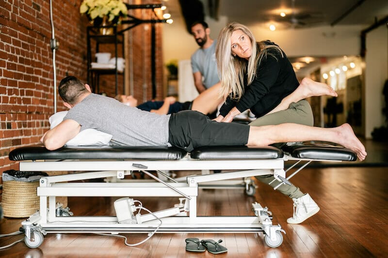 physical therapists working on patients legs in clinic