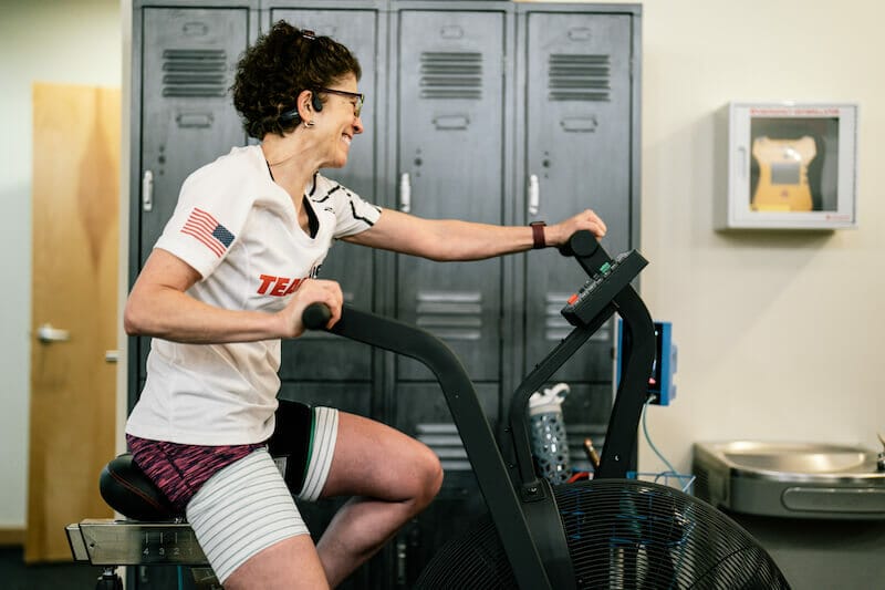 patient at villanova physical therapy clinic riding stationary bike in white athletic t-shirt
