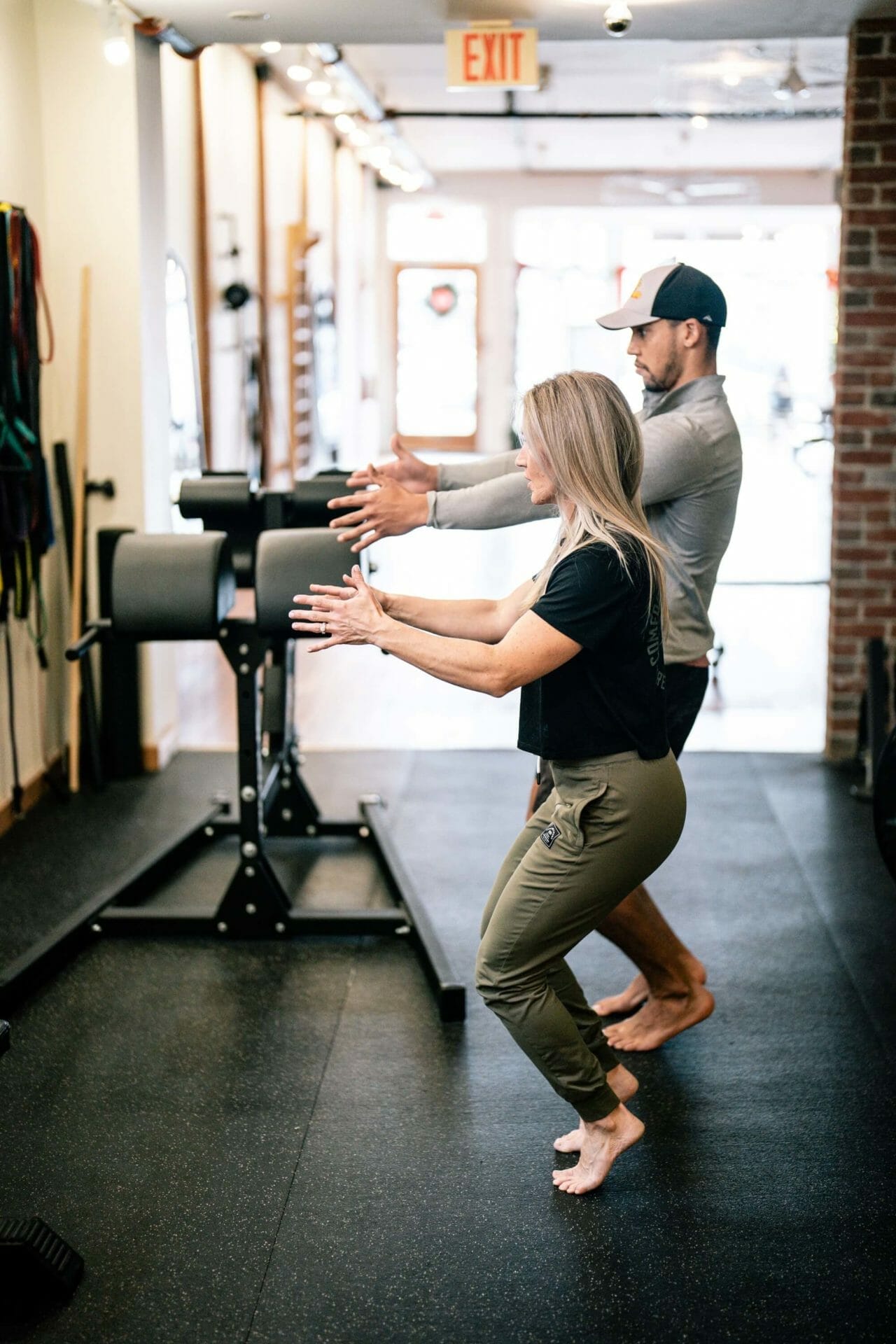 Man in a cap doing an exercise with a therapist